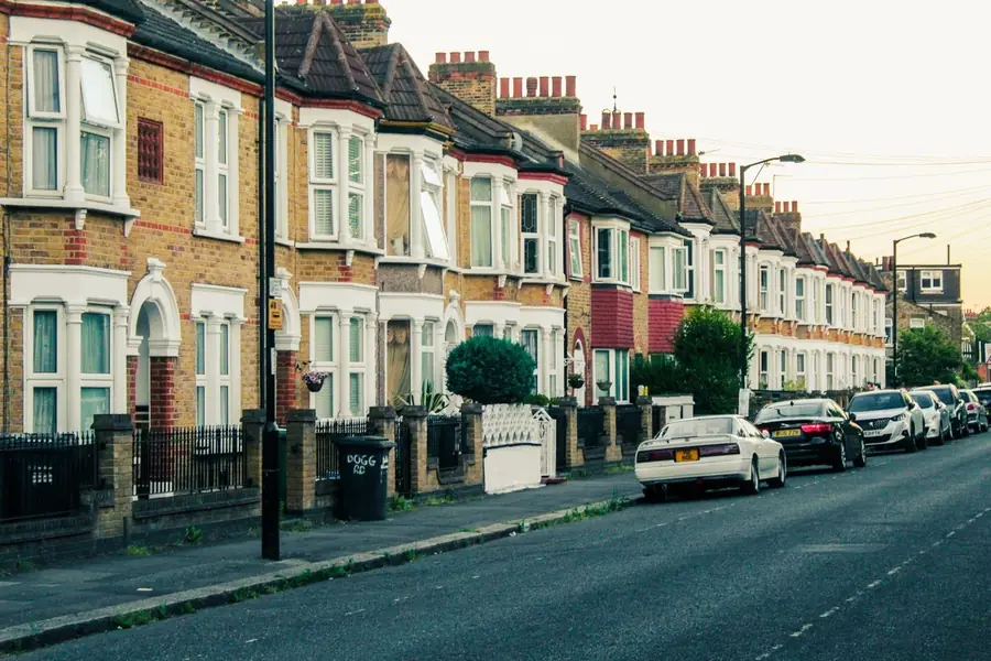 Bay-fronted houses along a suburban street with small roofs over each bay