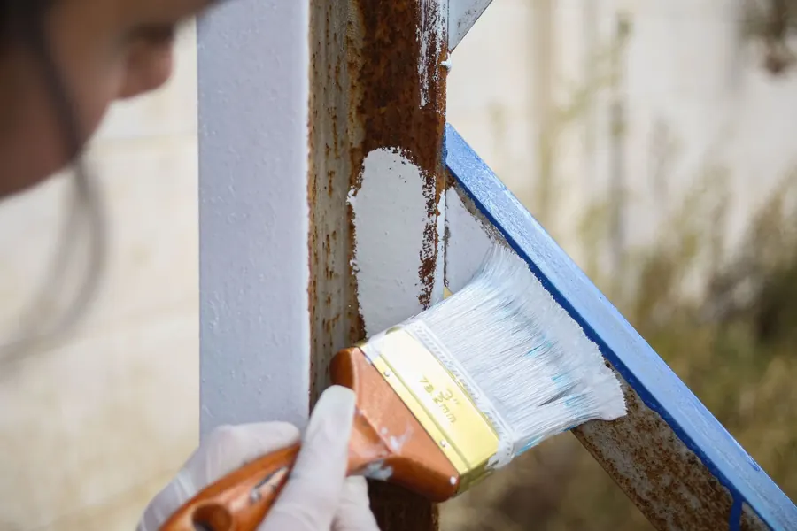 Rust being treated and painted over on cast iron metalwork, the standard repair for Croydon rainwater goods
