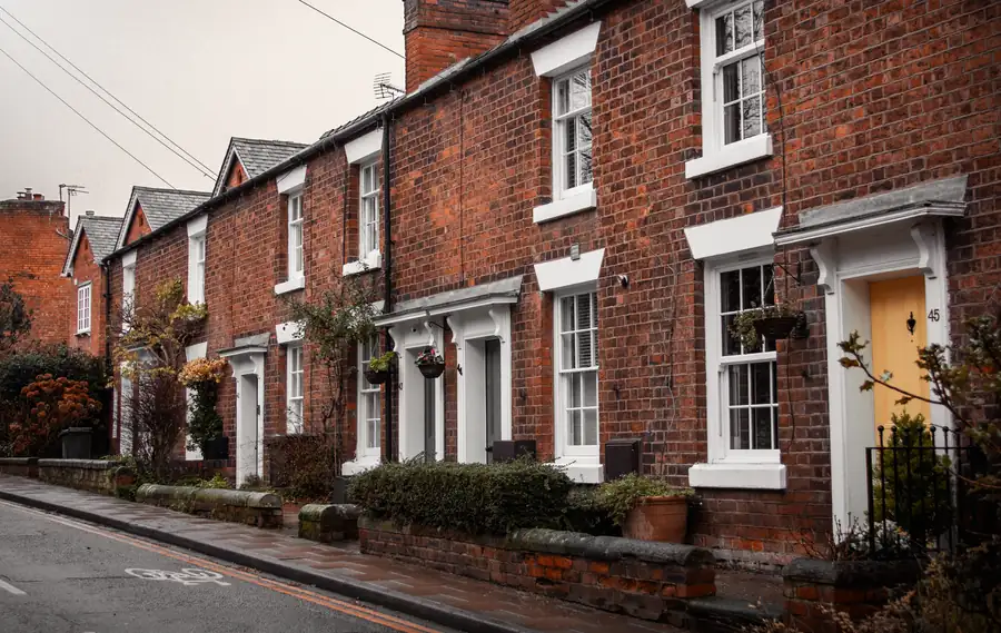 Period brick terraced houses with original gutters and downpipes on an overcast day