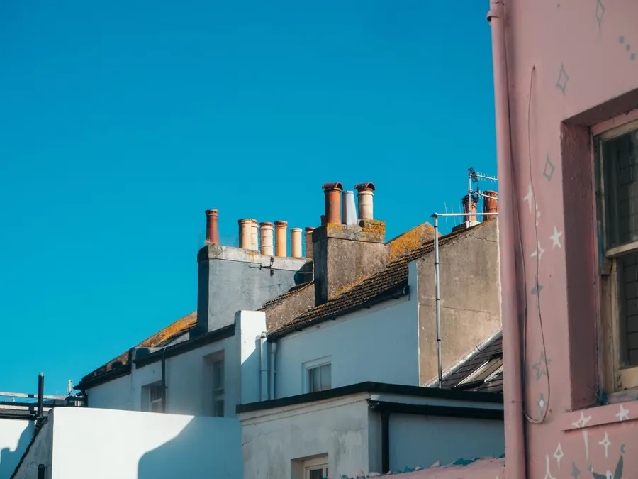 Rendered chimney stacks with rows of clay pots straddling the party walls of joined terraced houses