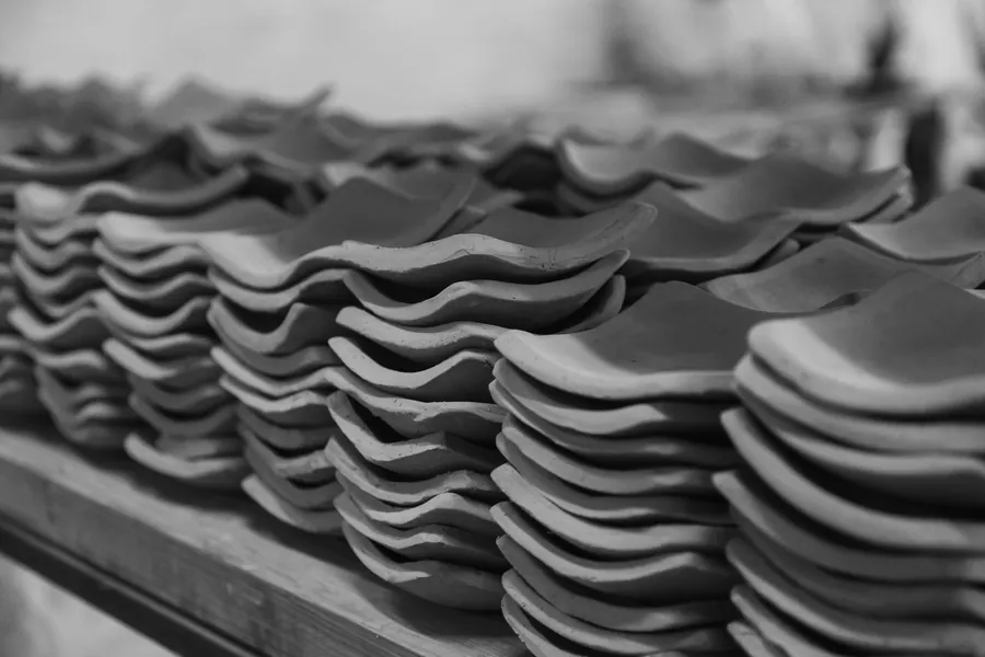 Stacks of salvaged clay plain tiles sorted and ready for re-laying on a roof