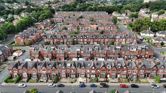 Dense rows of terraced houses with tiled roofs baking in summer sun